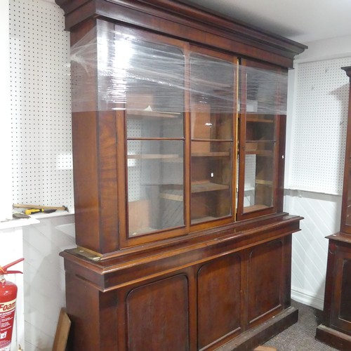 554 - A large Victorian mahogany glazed Bookcase, overhanging moulded cornice above three large glazed cup... 