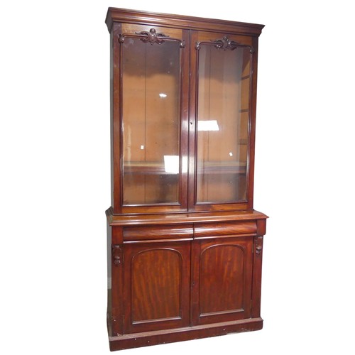 556 - A Victorian mahogany glazed Bookcase, moulded cornice above two large glazed doors with carved pedim... 