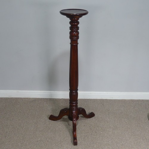 665 - A mahogany Torchere / Plant Stand, circular top raised on carved and reeded column and tripod base, ... 