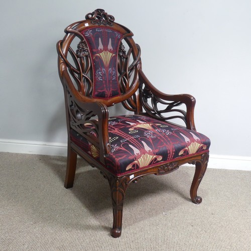 714 - An Art Nouveau style carved mahogany upholstered Armchair, back rest with scrolled and pierced styli... 