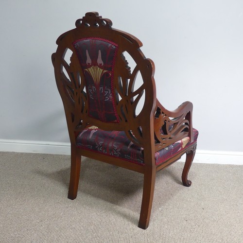 714 - An Art Nouveau style carved mahogany upholstered Armchair, back rest with scrolled and pierced styli... 