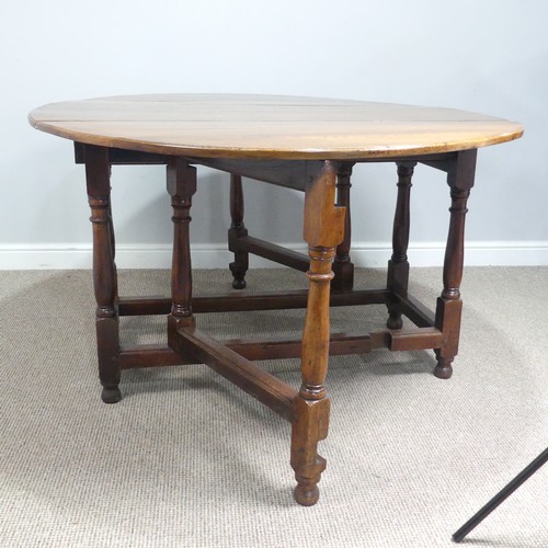 613 - A 18th century oak gate leg drop-leaf dining Table, circa 1750, raised on turned legs and square sup... 