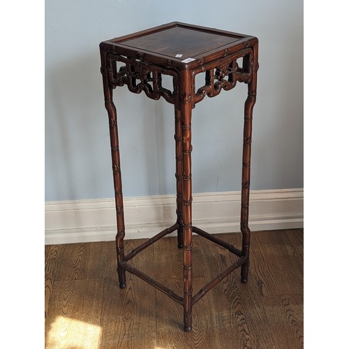 141 - An antique Chinese hardwood Plant Stand, square top above carved foliate frieze, raised on bamboo st... 