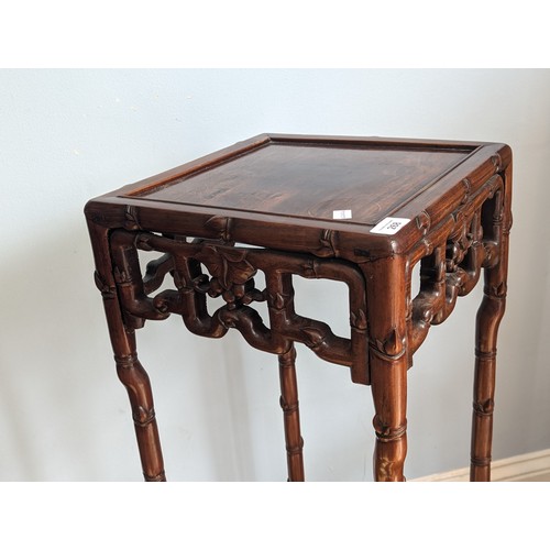 141 - An antique Chinese hardwood Plant Stand, square top above carved foliate frieze, raised on bamboo st... 