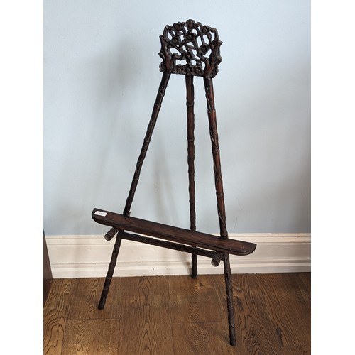 144 - An antique Chinese hardwood artists Easel, with carved and pierced foliate pediment raised on three ... 