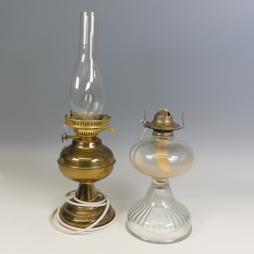 496 - An antique clear glass Oil Lamp, H 27 cm, together with a brass Oil lamp, which has been electrified... 