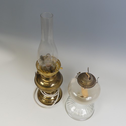 496 - An antique clear glass Oil Lamp, H 27 cm, together with a brass Oil lamp, which has been electrified... 