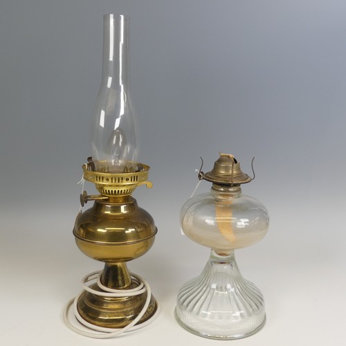 496 - An antique clear glass Oil Lamp, H 27 cm, together with a brass Oil lamp, which has been electrified... 