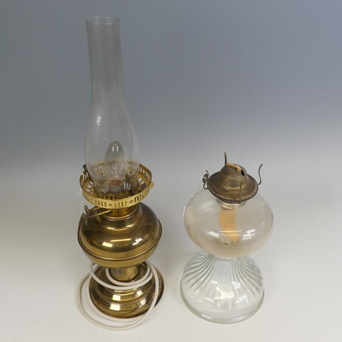 496 - An antique clear glass Oil Lamp, H 27 cm, together with a brass Oil lamp, which has been electrified... 