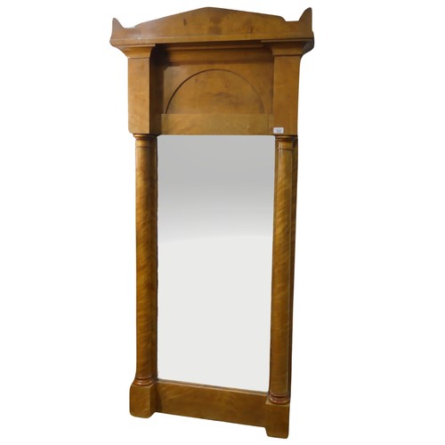 670 - A late 19th century Biedermeier pillar Mirror, possibly satinwood or maple, the shaped cornice above... 