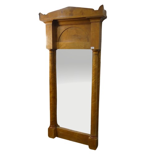 670 - A late 19th century Biedermeier pillar Mirror, possibly satinwood or maple, the shaped cornice above... 