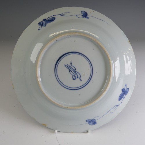 17 - A near pair of early 18thC Chinese porcelain blue and white Plates, the well decorated with flower b... 