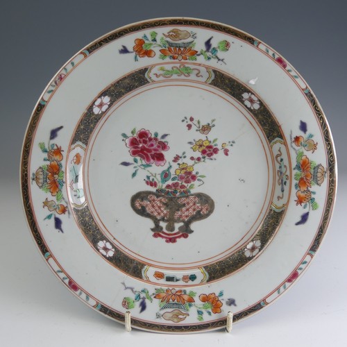 24 - An 18thC Chinese porcelain famille rose Charger, c. 1730, the well decorated with famille jaune bowl... 