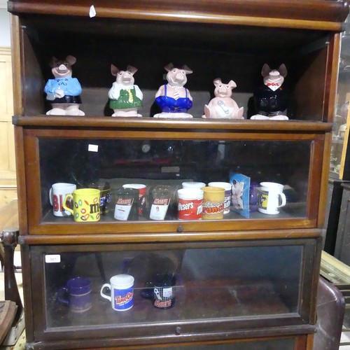 253 - A set of five Natwest wade Pigs, together with sixteen commemorative contemporary Cadbury mugs(a lot... 