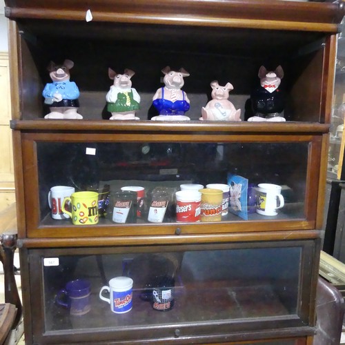 253 - A set of five Natwest wade Pigs, together with sixteen commemorative contemporary Cadbury mugs(a lot... 