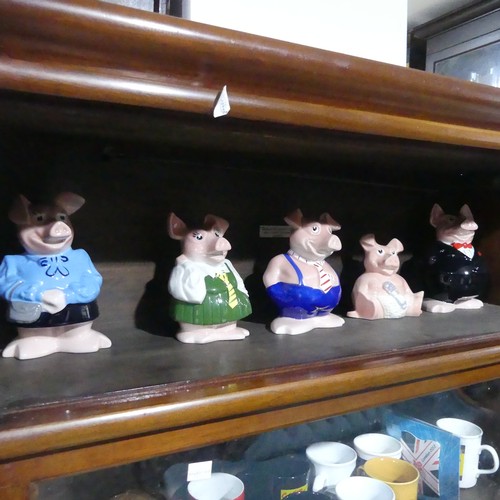 253 - A set of five Natwest wade Pigs, together with sixteen commemorative contemporary Cadbury mugs(a lot... 