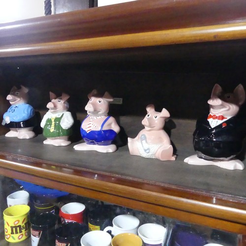 253 - A set of five Natwest wade Pigs, together with sixteen commemorative contemporary Cadbury mugs(a lot... 