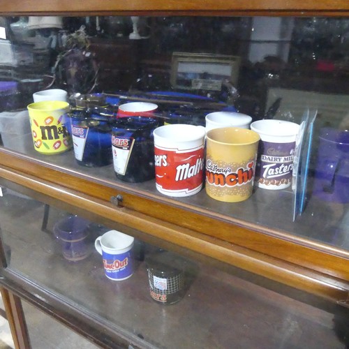 253 - A set of five Natwest wade Pigs, together with sixteen commemorative contemporary Cadbury mugs(a lot... 