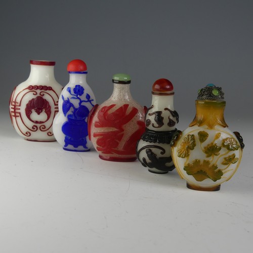 197 - A small quantity of Chinese overlayed glass Snuff Bottles, to comprise one with central bat motif on... 