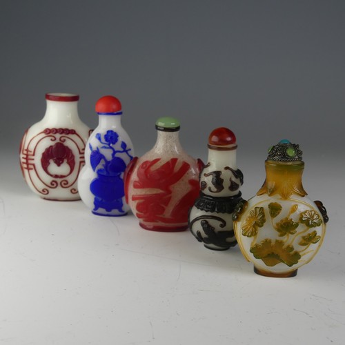 197 - A small quantity of Chinese overlayed glass Snuff Bottles, to comprise one with central bat motif on... 