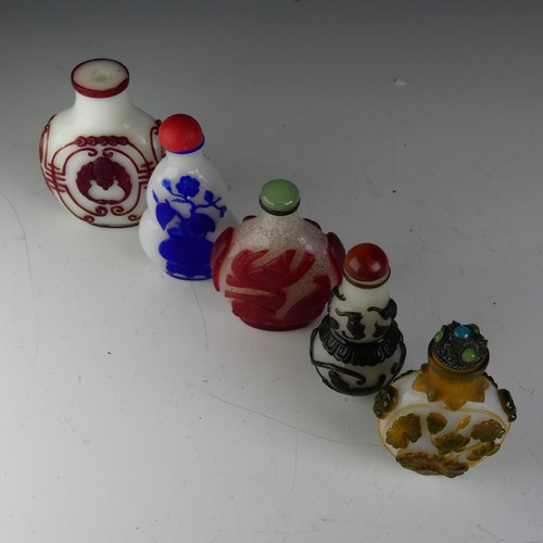 197 - A small quantity of Chinese overlayed glass Snuff Bottles, to comprise one with central bat motif on... 