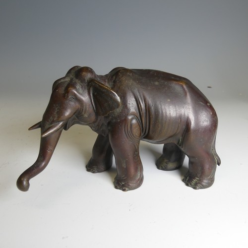 159 - A Japanese bronze model of an Elephant, modelled standing with its trunk slightly raised, bronze tus... 