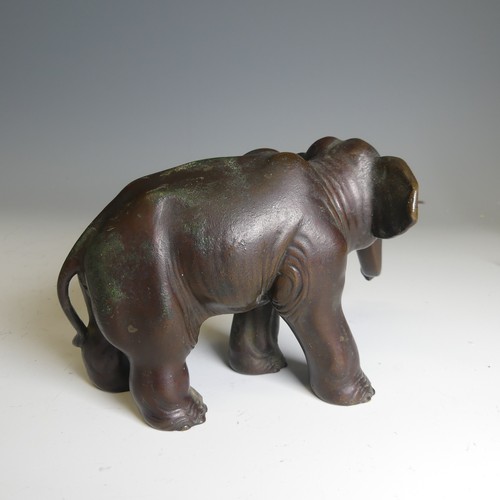 159 - A Japanese bronze model of an Elephant, modelled standing with its trunk slightly raised, bronze tus... 