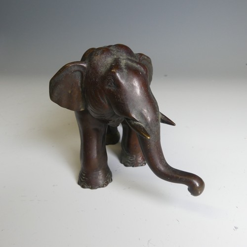 159 - A Japanese bronze model of an Elephant, modelled standing with its trunk slightly raised, bronze tus... 