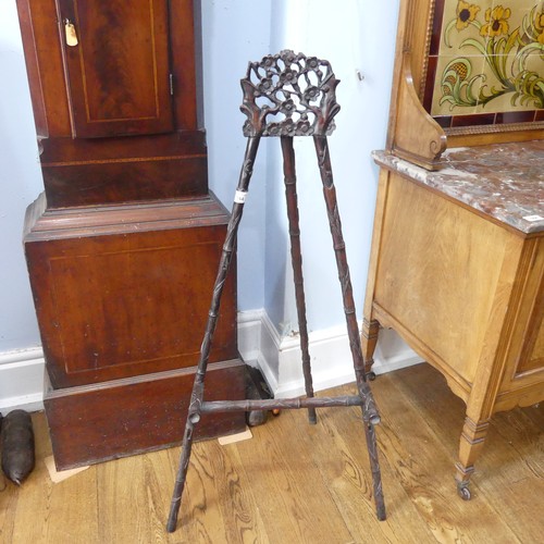 144 - An antique Chinese hardwood artists Easel, with carved and pierced foliate pediment raised on three ... 