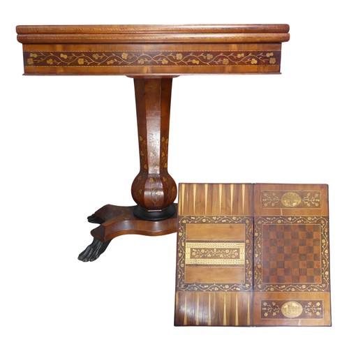 A 19th century Irish Killarney marquetry and yew games Table, hinged rectangular top inlaid with an oval reserve of Muckross Abbey, County Kerry, Ireland, bordered by trailing sprays of seamróg shamrocks and outlined with barber-pole stringing, parquetry bands and stiff leaves, enclosing playing surfaces for chess, backgammon and cribbage and further architectural landscapes, possibly Ross castle and Glena cottage, above a deep frieze inlaid with leaves and flowers, panelled 'garlic-mouth' column, serpentine rectangular base, claw feet, note small repair to hinged top and back, also some small damages please see images, W 79 cm x H 77 cm x D 42.5 cm.