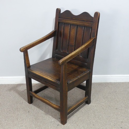 531 - An 18th century wainscot style oak Armchair, shaped headrest over panelled backrest and flanked by o... 