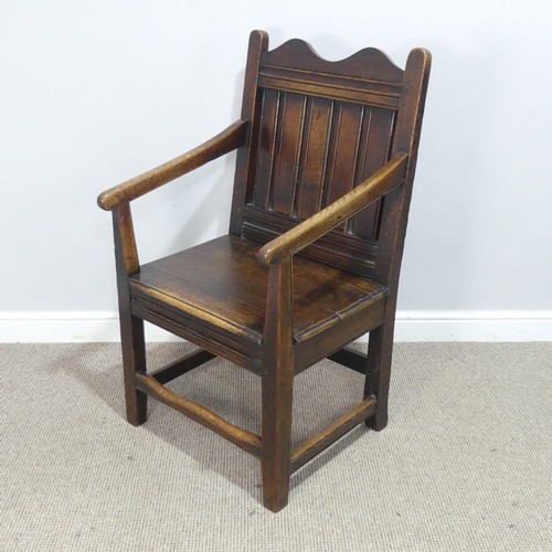 531 - An 18th century wainscot style oak Armchair, shaped headrest over panelled backrest and flanked by o... 