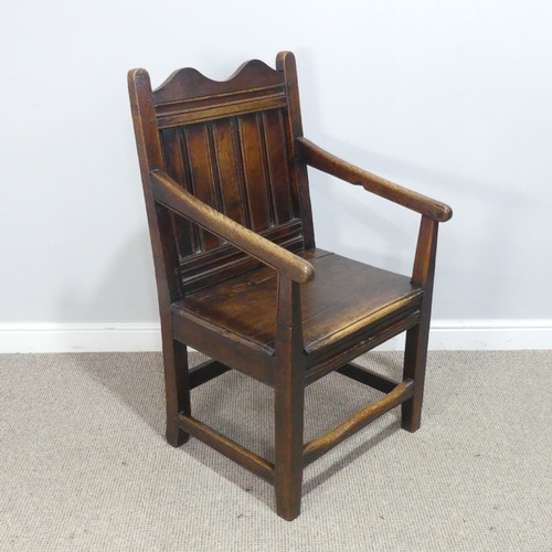 531 - An 18th century wainscot style oak Armchair, shaped headrest over panelled backrest and flanked by o... 