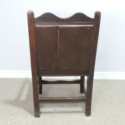 531 - An 18th century wainscot style oak Armchair, shaped headrest over panelled backrest and flanked by o... 