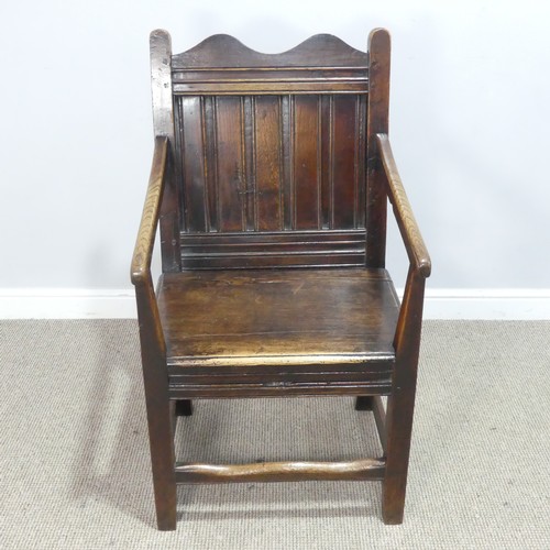 531 - An 18th century wainscot style oak Armchair, shaped headrest over panelled backrest and flanked by o... 