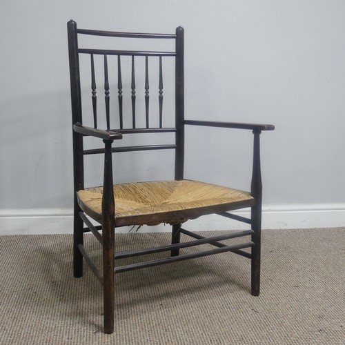 553 - In the manner of William Morris, an antique ebonised Sussex Chair, with turned bobbin back and rush ... 