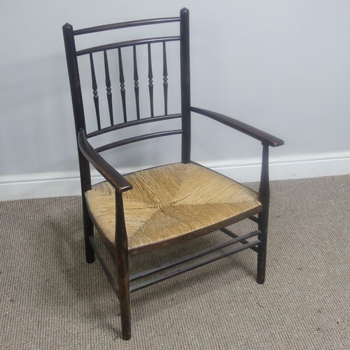 553 - In the manner of William Morris, an antique ebonised Sussex Chair, with turned bobbin back and rush ... 