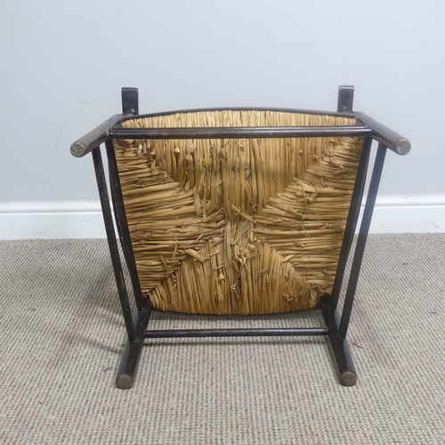 553 - In the manner of William Morris, an antique ebonised Sussex Chair, with turned bobbin back and rush ... 