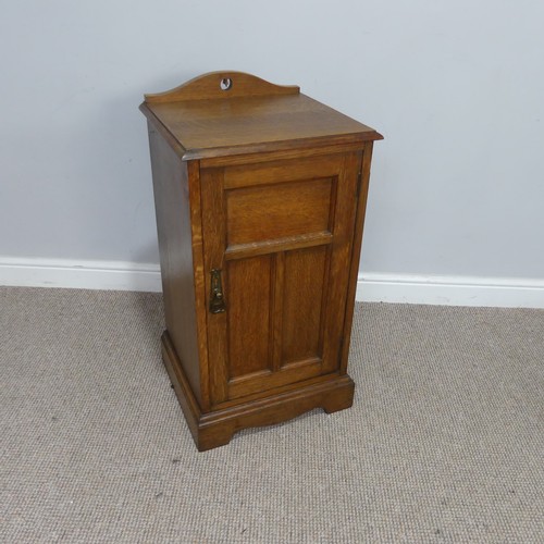 558 - An Arts and crafts oak bedside Cabinet, pierced top over panelled doors, raised on shaped plinth bas... 