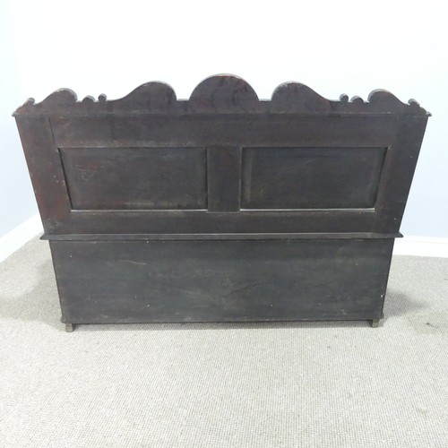 580 - A late Victorian carved oak Settle, foliate carved backrest flanked by scroll arms in the form of dr... 