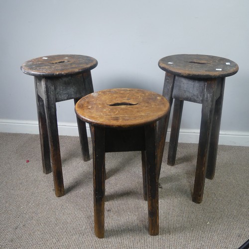 427 - Three antique stained pine kitchen Stools, with oval tops and pierced handles, raised on chamfered s... 