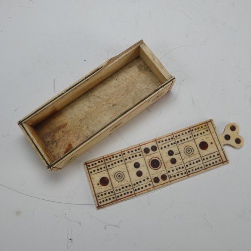 177 - An early 19th century French Prisoner of War carved bone Games Box, the sliding cover pierced for cr... 