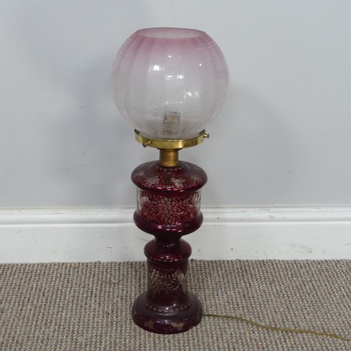 565 - An antique ruby glass electrified Oil Lamp, with etched glass shade, H 49 cm, together with two bras... 