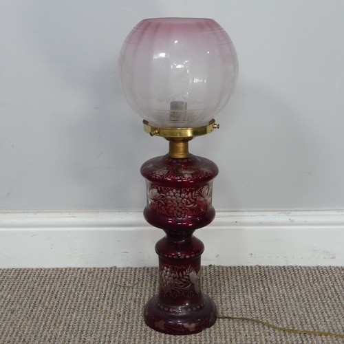 565 - An antique ruby glass electrified Oil Lamp, with etched glass shade, H 49 cm, together with two bras... 