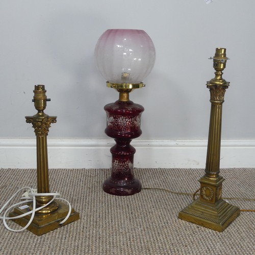 565 - An antique ruby glass electrified Oil Lamp, with etched glass shade, H 49 cm, together with two bras... 