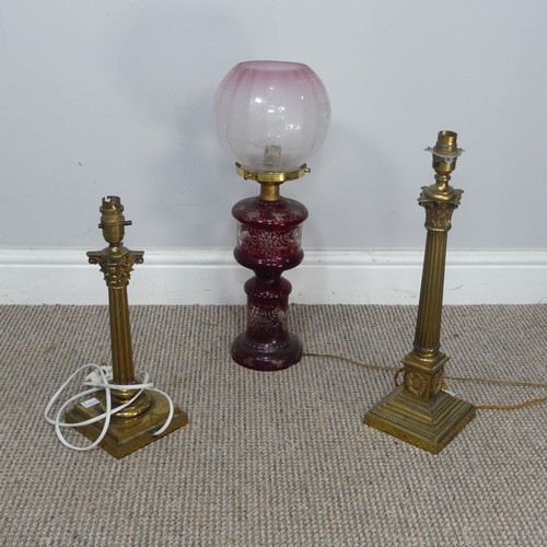 565 - An antique ruby glass electrified Oil Lamp, with etched glass shade, H 49 cm, together with two bras... 