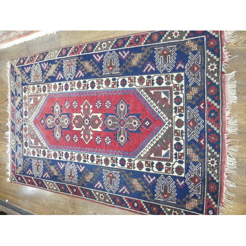 587 - Tribal Rugs; a Turkish Rug, blue and red ground with all over geometric pattern set within a wide bo... 