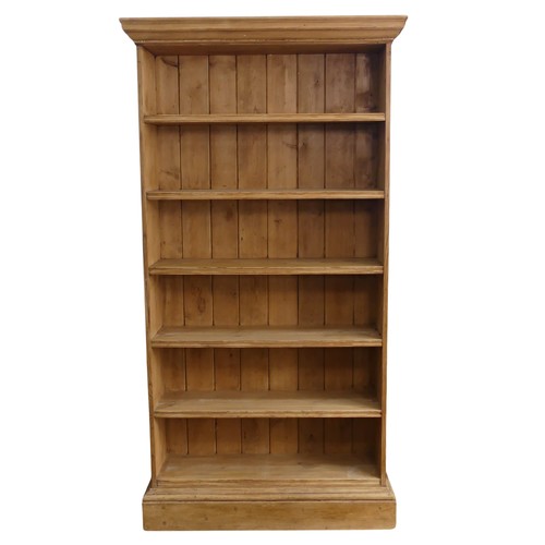 460 - A large antique pine open Bookcase, moulded cornice over five deep shelves, raised on plinth base, W... 