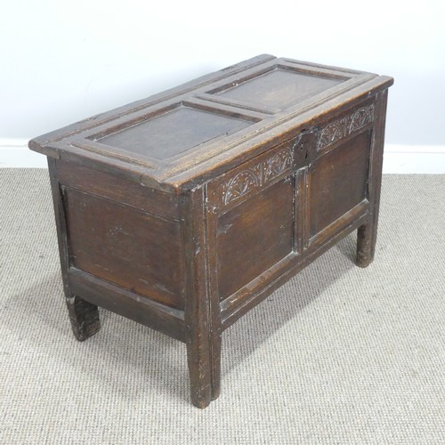 497 - An 18th century small oak Coffer, panelled top with pin hinges, above carved panel edges, raised on ... 