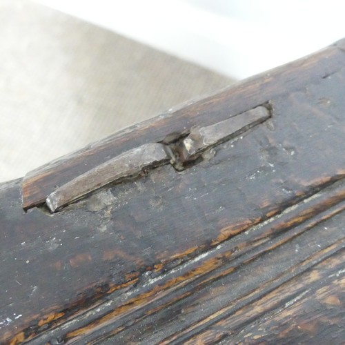 497 - An 18th century small oak Coffer, panelled top with pin hinges, above carved panel edges, raised on ... 